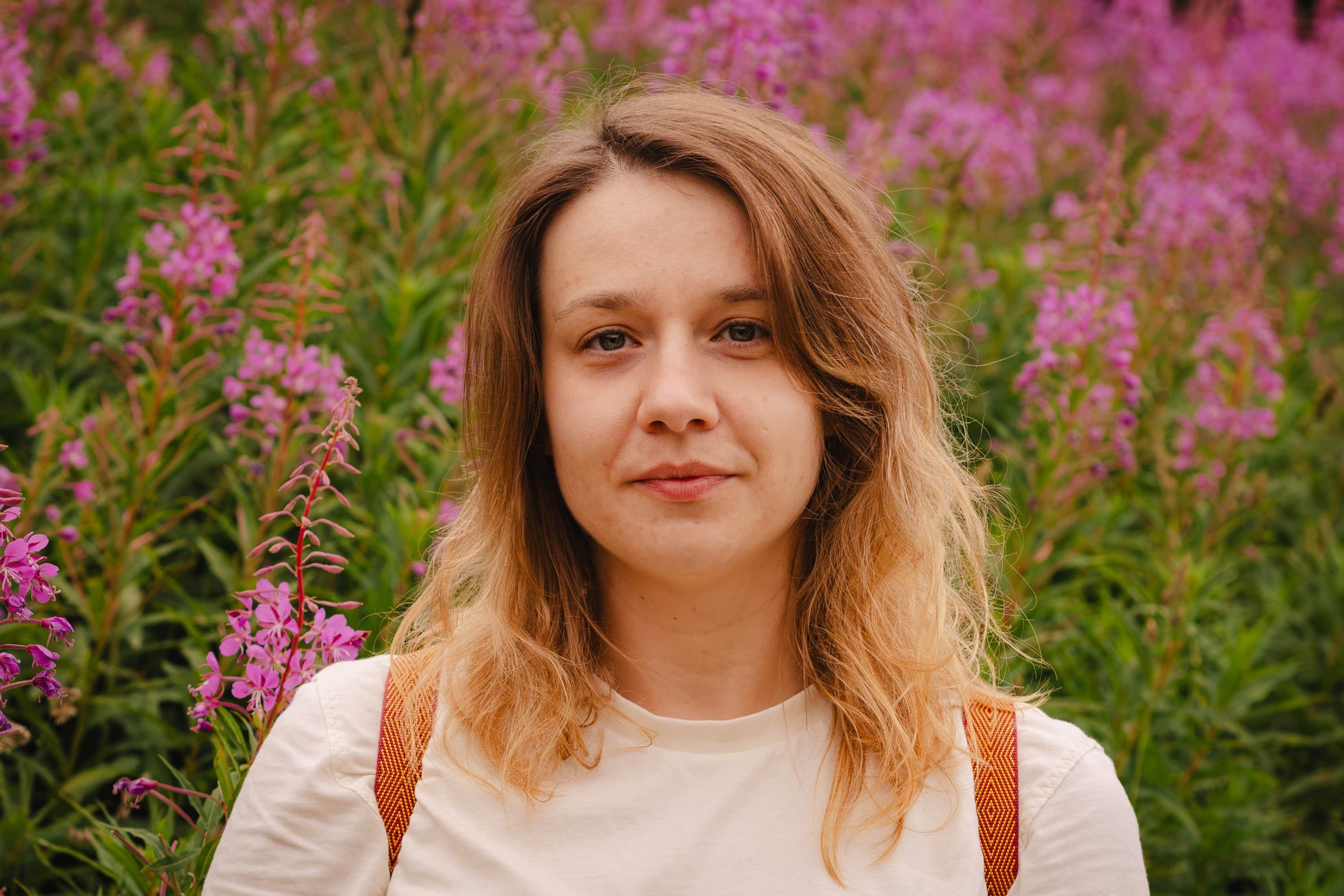 Woman smiling among pink fireweed